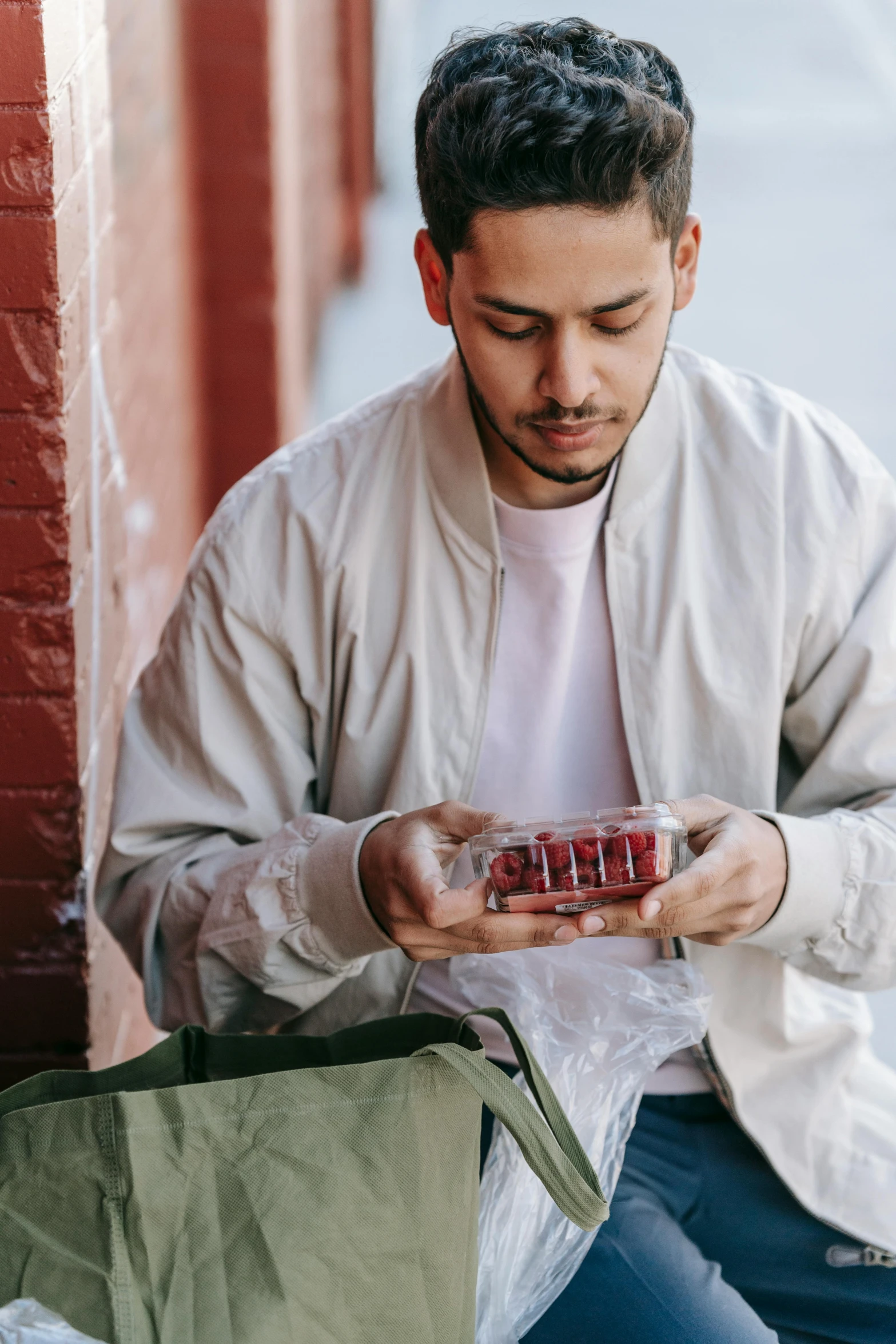 a man sitting on the ground looking at his cell phone, pexels contest winner, getting groceries, maroon, pete davidson, man standing