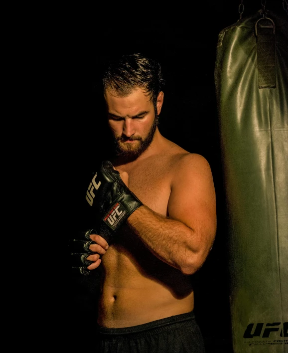 a shirtless man standing next to a punching bag, trending on reddit, figuration libre, actor liam hemsworth, museum quality photo, ufc, square