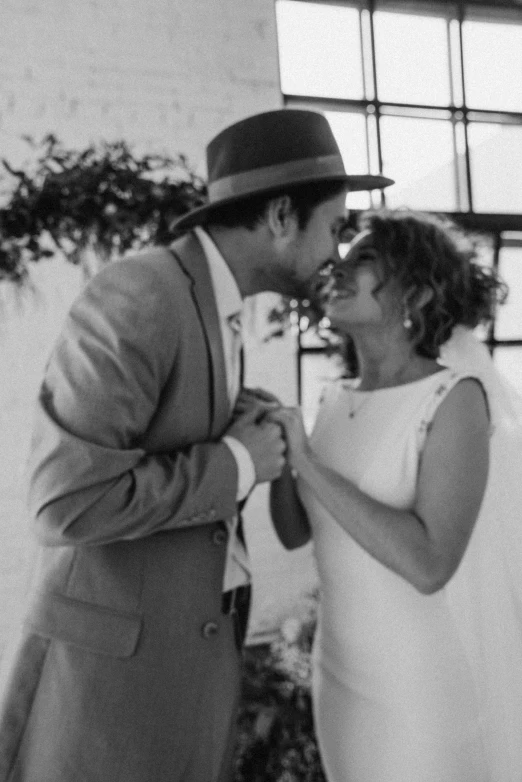 a black and white photo of a bride and groom, by Liza Donnelly, happening, tipping his fedora, lorena avarez, actor, grainy low quality