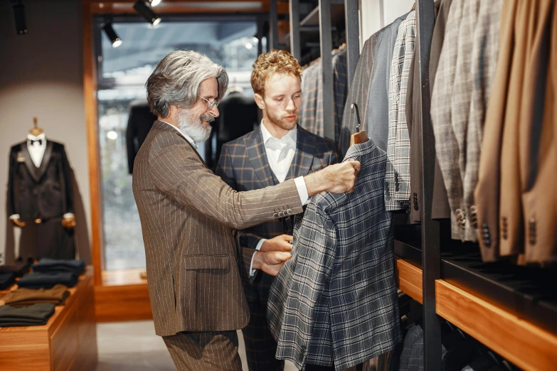 a man standing next to another man in a suit shop, pexels, renaissance, tartan garment, thumbnail, brown, transforming