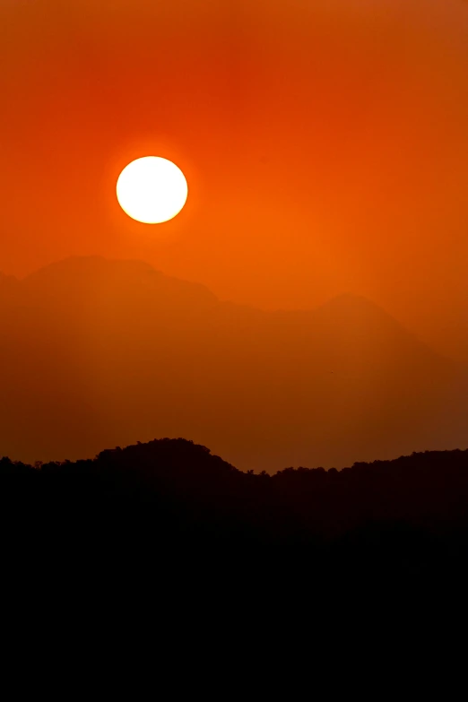 the sun is setting over a mountain range, by Rajesh Soni, pexels contest winner, romanticism, heat wave, shot on 1 5 0 mm, taiwan, big red sun