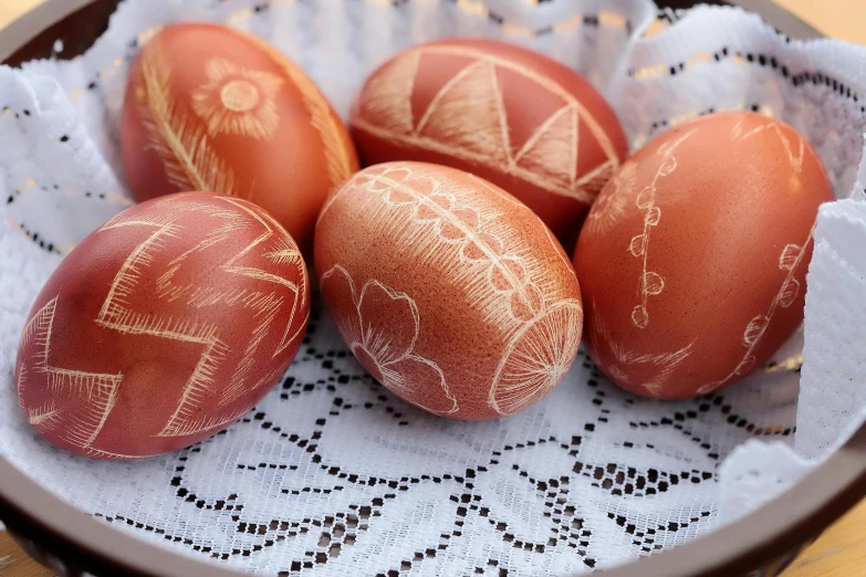 four painted eggs in a bowl on a table, intricate wirings, red ocher, cottagecore hippie, engraved