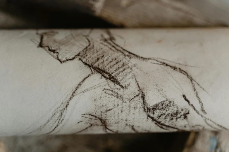 a close up of a drawing on a piece of paper, a charcoal drawing, trending on pexels, old manuscripts and scrolls, figure drawing, found in a cave made of clay, over the shoulder