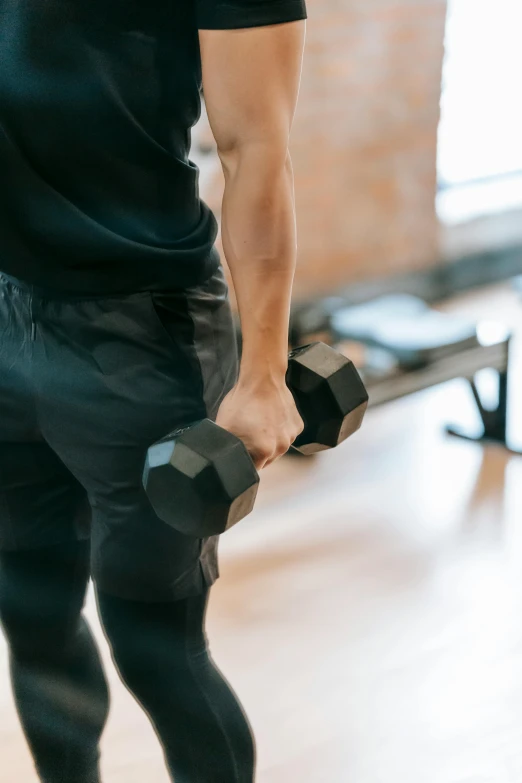 a man holding a pair of dumbbells in a gym, by Niko Henrichon, pexels contest winner, renaissance, zoomed out full body, lower back, dynamic movement, kailee mandel