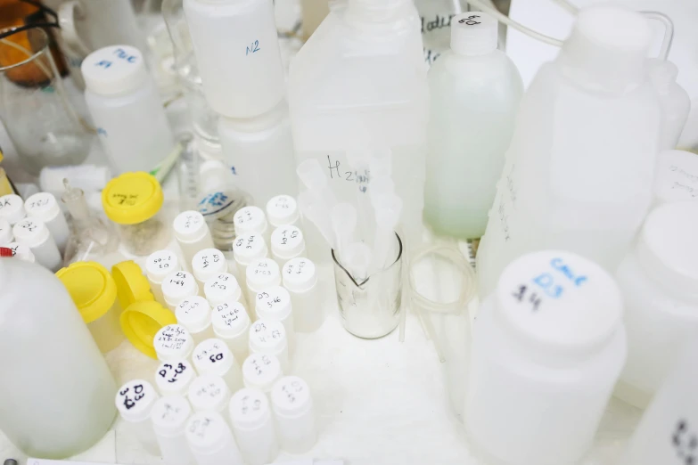 a bunch of bottles sitting on top of a table, a picture, in a lab, white plastic, thumbnail, formulae