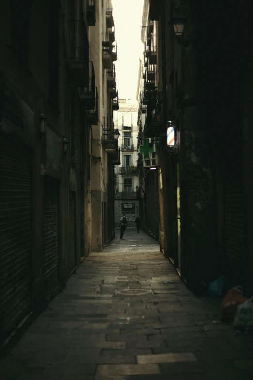 a narrow alley with a person walking down it, inspired by Elsa Bleda, pexels contest winner, gothic quarter, low quality photo, late afternoon, an abandoned dystopian city