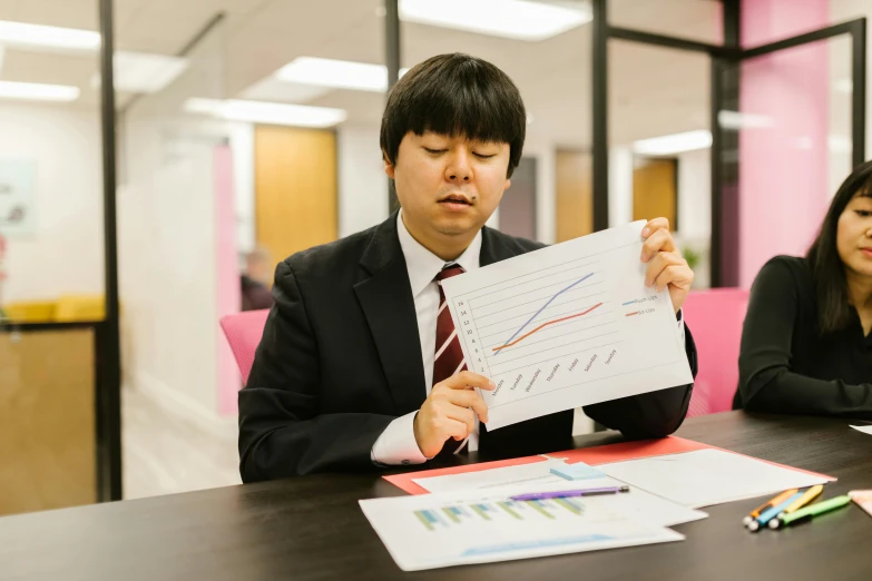 a man and a woman sitting at a table with papers, a picture, unsplash, shin hanga, sat in an office, holding notebook, charts, profile image