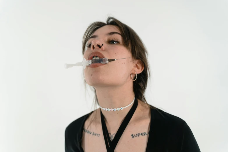 a woman with a needle in her mouth, inspired by Elsa Bleda, trending on pexels, body modification, with a white background, yung lean, breathing