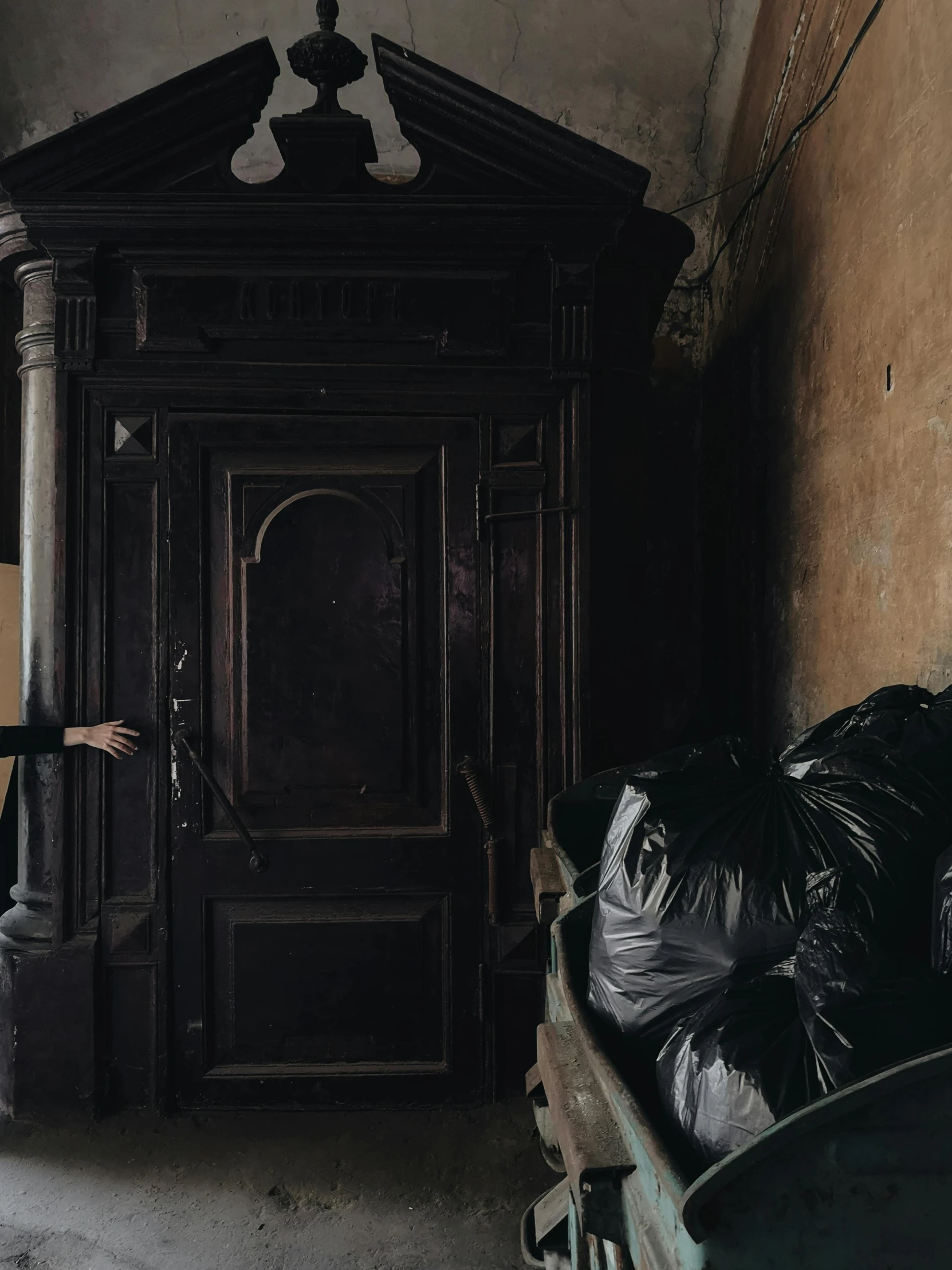 a man that is standing in front of a door, pexels contest winner, arte povera, mad trash bags, gothic mansion room, profile image, furniture overturned