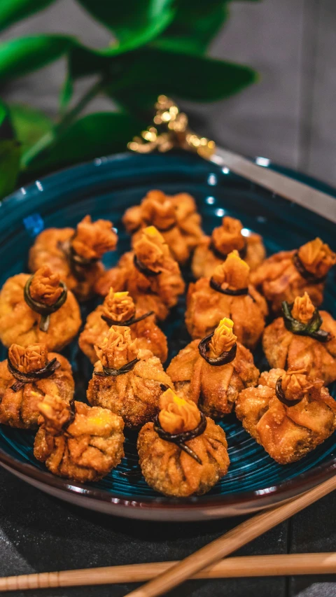 a blue plate topped with fried food next to chopsticks, 9 peacock tails, thumbnail, puffy, kuntilanak