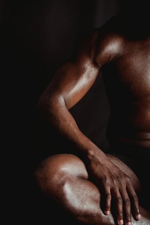 a man sitting in front of a laptop computer, an album cover, by Alexander Mann, pexels contest winner, hyperrealism, muscle striation visible, black skin, thighs close up, body building blacksmith