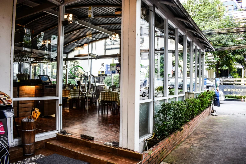 a bicycle parked in front of a restaurant, glass room, restaurant exterior photography, bangkok, fan favorite