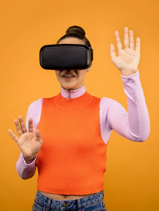 a woman wearing a virtual reality headset on an orange background, by Matthias Stom, hand gesture, model is wearing techtical vest, promotional image, black