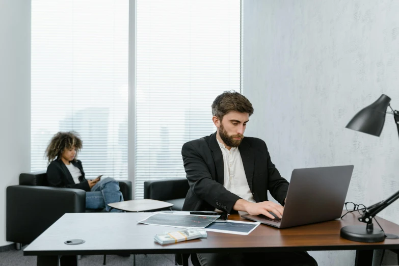 a man sitting at a desk working on a laptop, pexels contest winner, medium shot of two characters, lachlan bailey, empty office, caucasian