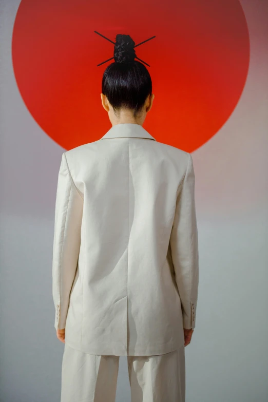 a woman standing in front of a red sun, an album cover, inspired by Marina Abramović, trending on pexels, bauhaus, white jacket, back view, subject detail: wearing a suit, nishihara isao