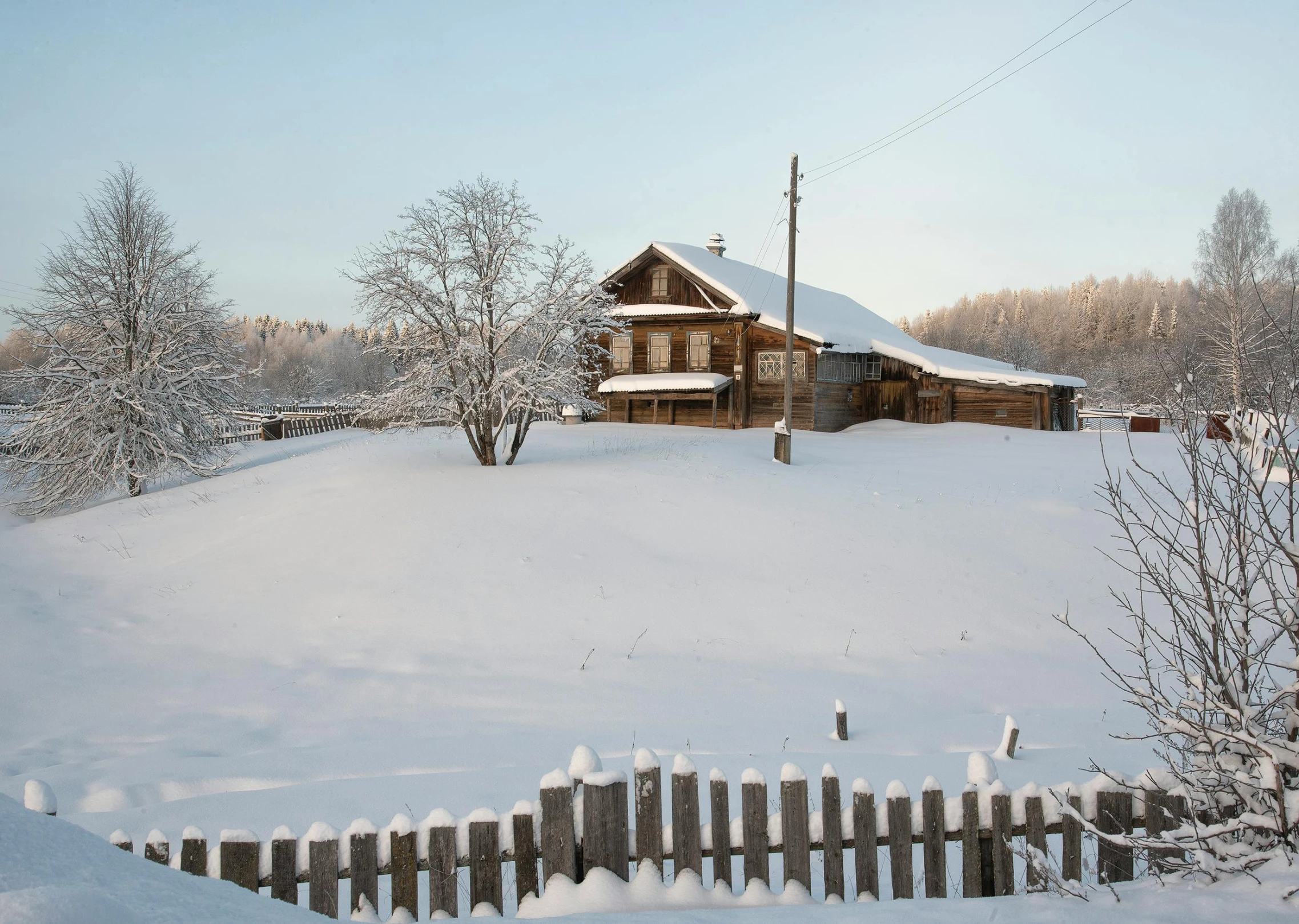 a wooden house sitting on top of a snow covered field, inspired by Isaac Levitan, pexels contest winner, exterior shot, white, southern slav features, ecovillage