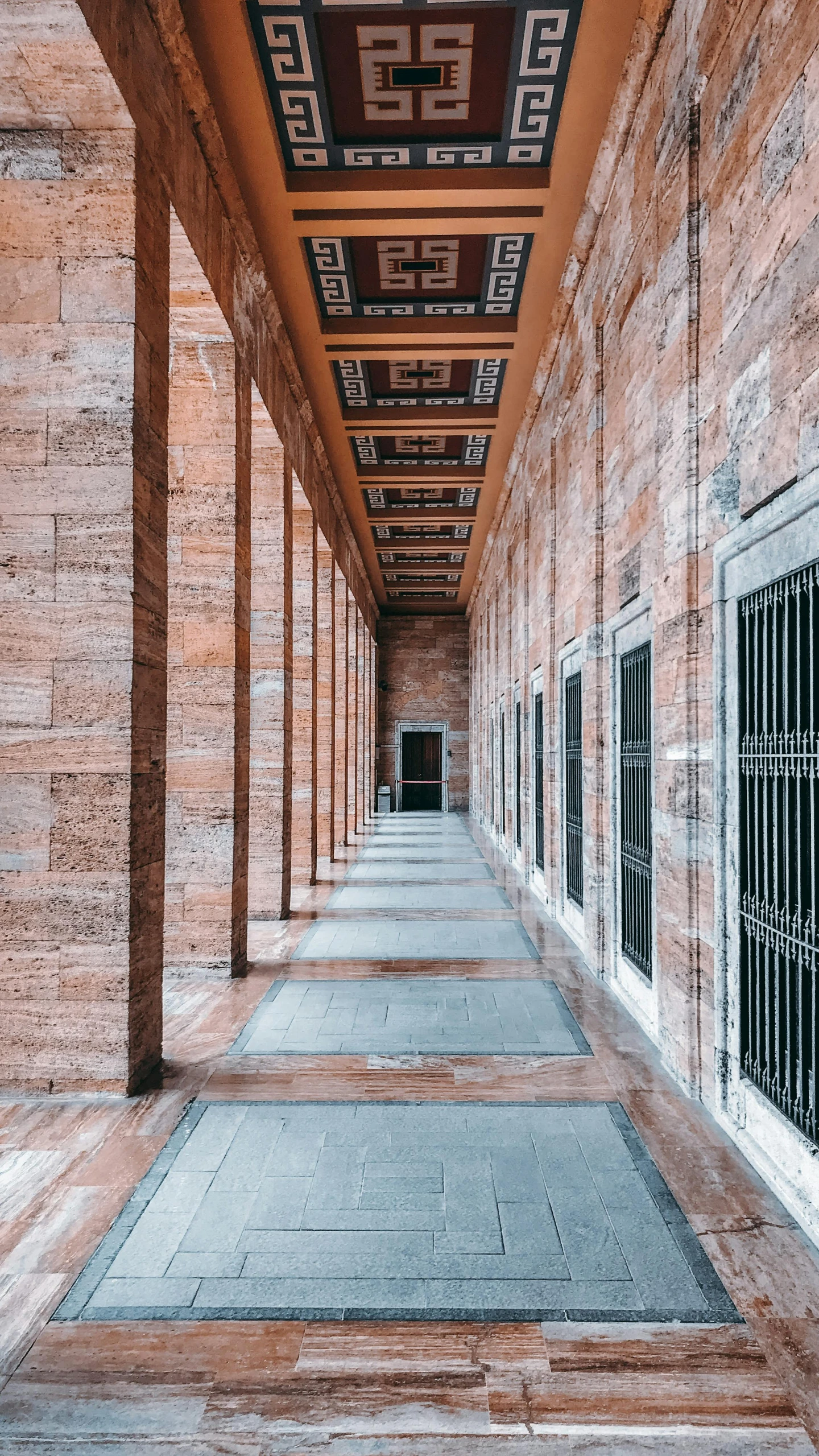 a long hallway in an old brick building, inspired by David Chipperfield, pexels contest winner, berlin secession, mausoleum, high quality photo, roma, wooden banks