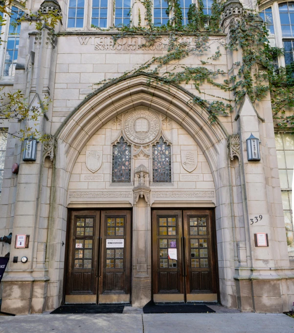 a couple of doors that are in front of a building, by William Woodward, unsplash, vancouver school, neo - gothic architecture, high school badge, white stone arches, from wheaton illinois