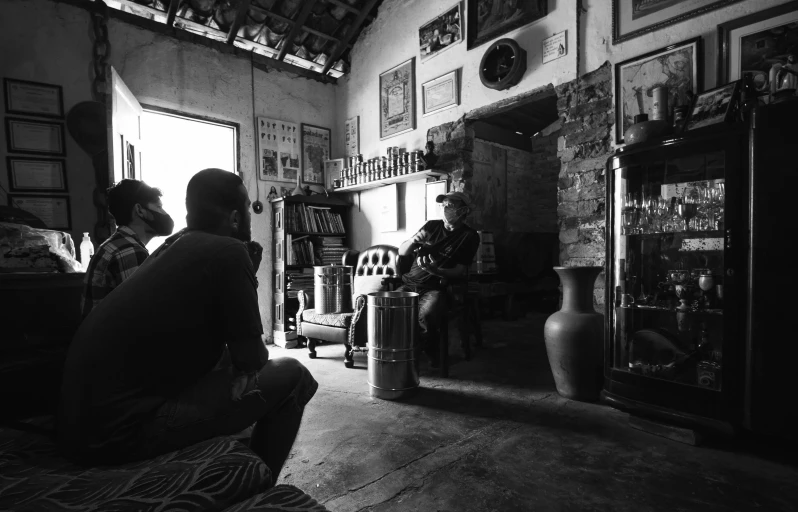 a group of people sitting in a living room, visual art, samburu, black and white picture, coffee shop, maintenance photo