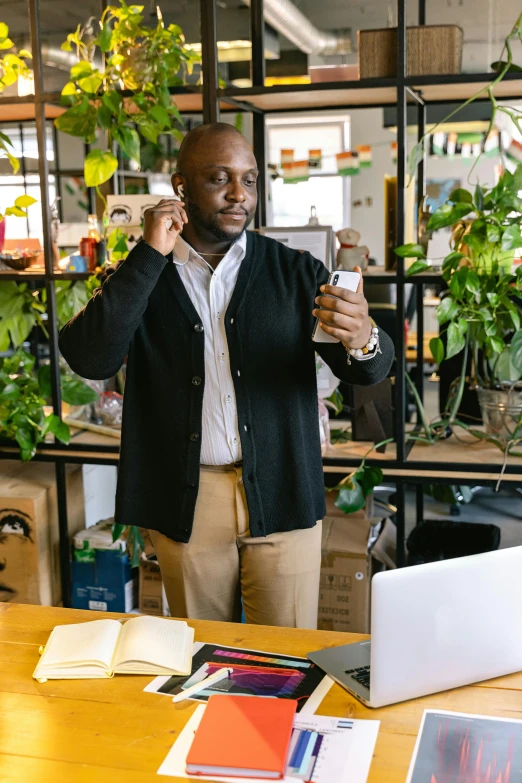 a man talking on a cell phone in an office, pexels contest winner, renaissance, next to a plant, african man, adafruit, wearing business casual dress