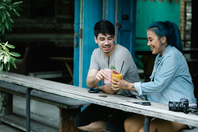 a man and a woman sitting at a picnic table, pexels contest winner, happening, aussie baristas, avatar image, holding a drink, joel torres
