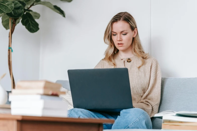 a woman sitting on a couch using a laptop, trending on pexels, samara weaving, avatar image, professional image, woman with braided brown hair