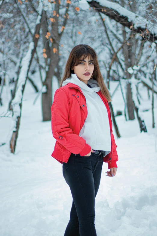 a woman in a red jacket is standing in the snow, inspired by Elsa Bleda, pexels contest winner, beautiful iranian woman, at a park, avatar image, casual clothing