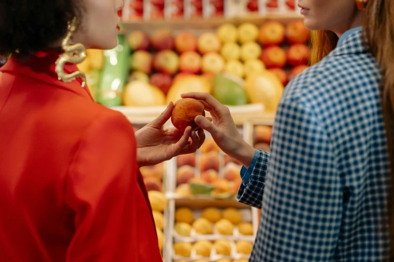 a couple of women standing next to each other in a store, pexels contest winner, she is easting a peach, avatar image, uncropped, apple orange