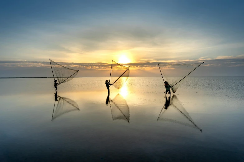 a group of people standing on top of a body of water, by Ibrahim Kodra, unsplash contest winner, fishing, beautiful backlight, netting, farming