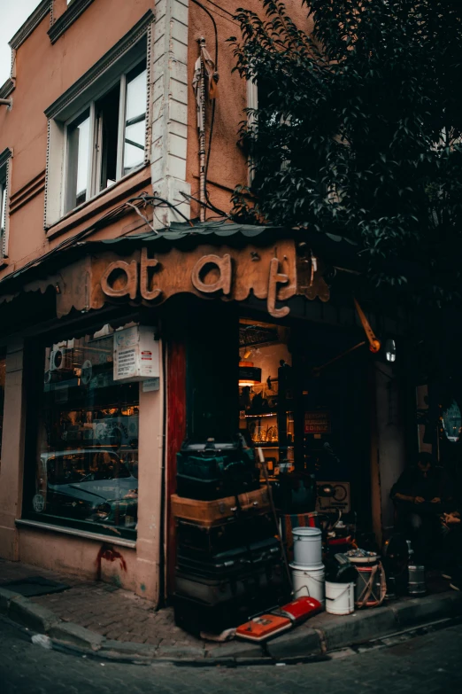 a building sitting on the side of a street, pexels contest winner, cozy cafe background, istanbul, exiting store, black and terracotta