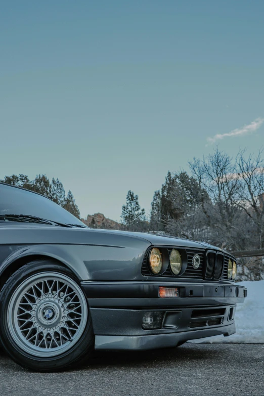 a black car parked on the side of the road, inspired by Harry Haenigsen, unsplash contest winner, renaissance, bmw e 3 0, snow glow, profile image, steel gray body