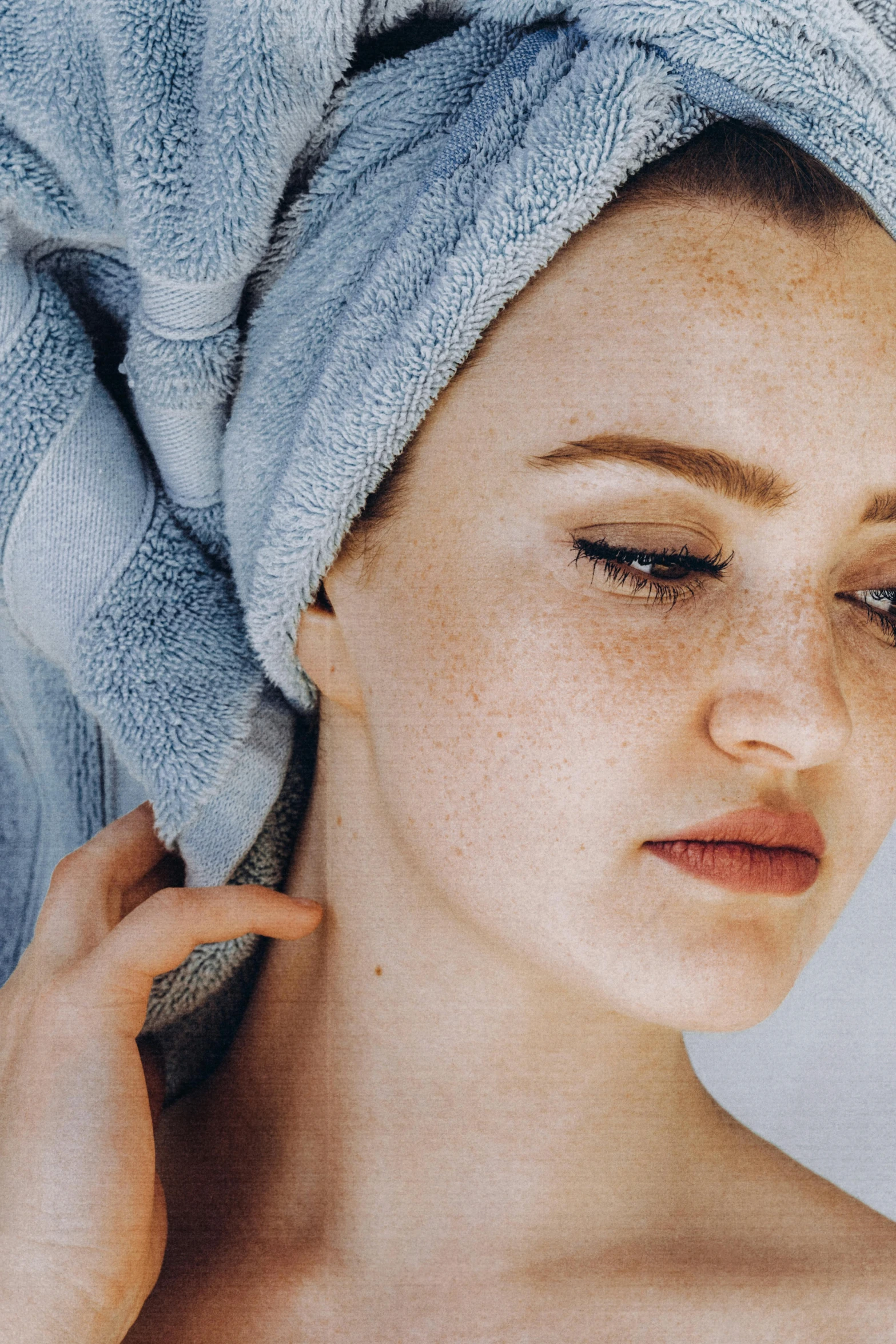 a woman with a towel wrapped around her head, by Carey Morris, trending on pexels, renaissance, freckled pale skin, defined cheekbones, smooth blue skin, detailed face )