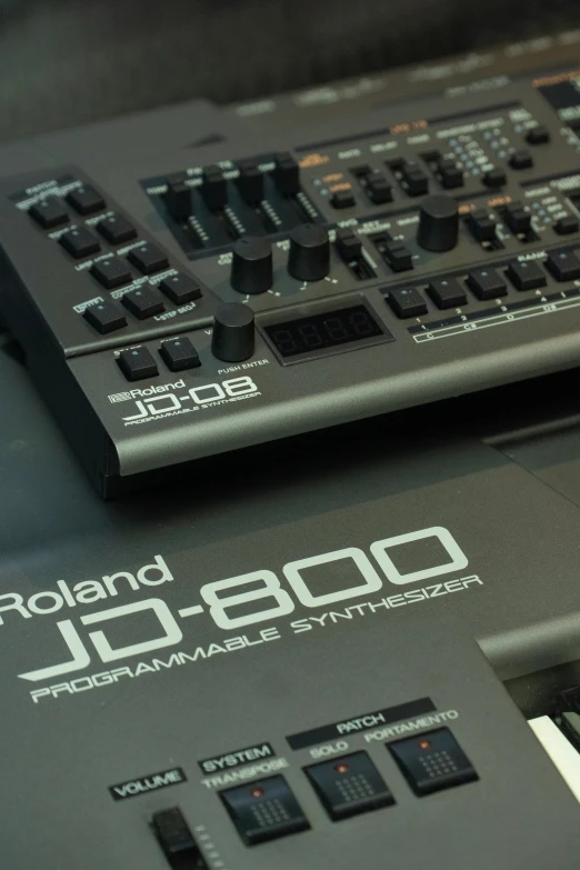 a keyboard sitting on top of a table next to a keyboard, roland, an instrument, 800t, bottom body close up