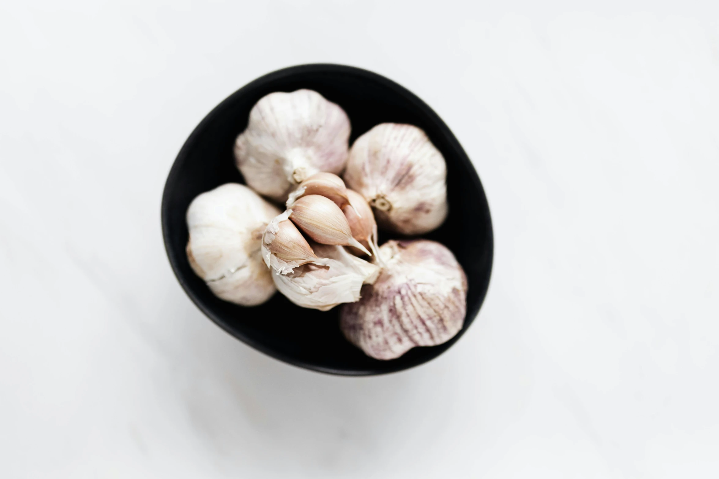 a black bowl filled with garlic on top of a white table, by Carey Morris, unsplash, silver haired, blushing, rabbit ears, transparent background