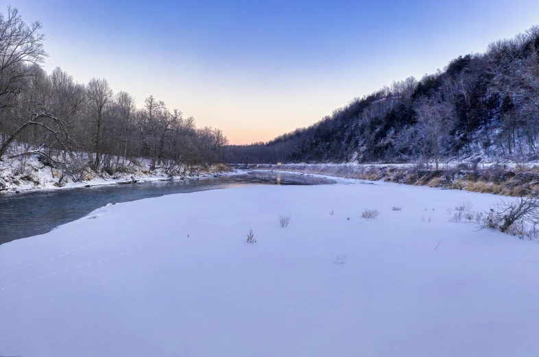 a river running through a snow covered forest, by Jeffrey Smith, pexels contest winner, twilight ; wide shot, panorama view, looking over west virginia, sparse frozen landscape