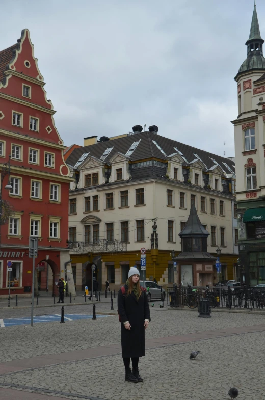 a woman standing in the middle of a city square, art nouveau, in legnica!!!, stacked buildings, unedited, other smaller buildings