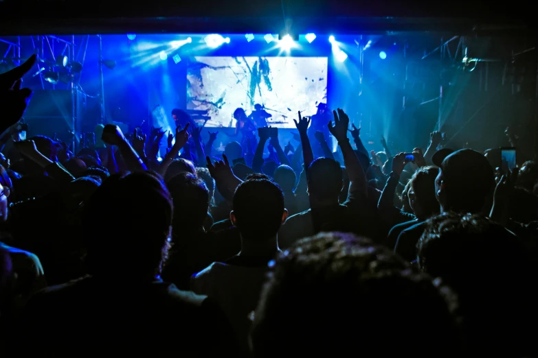 a crowd of people at a concert with their hands in the air, a cartoon, pexels, in a nightclub, large screen, promo image, show from below