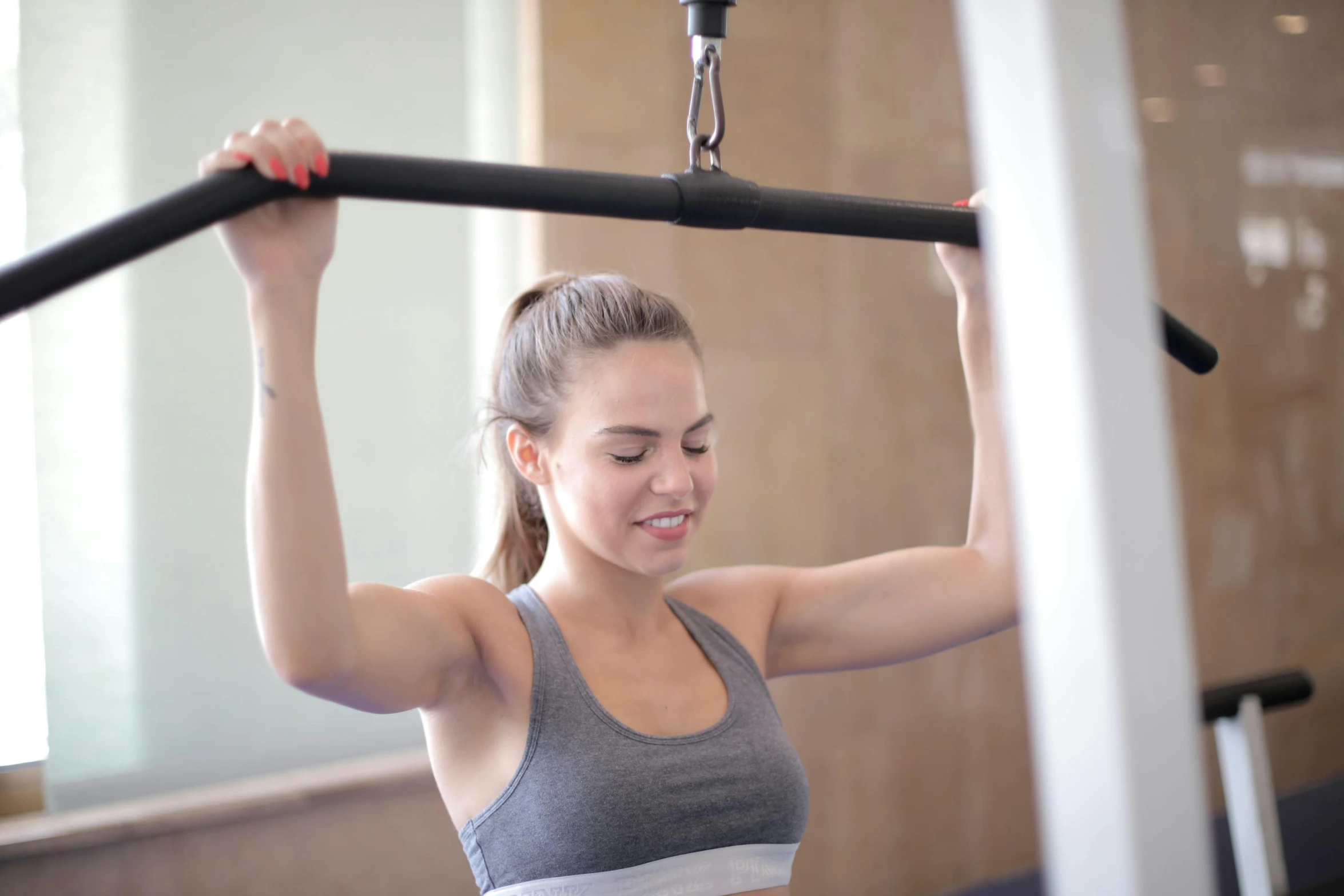 a woman using a pull up bar in a gym, by Emma Andijewska, private press, manuka, profile image, cara delevigne, holding a staff