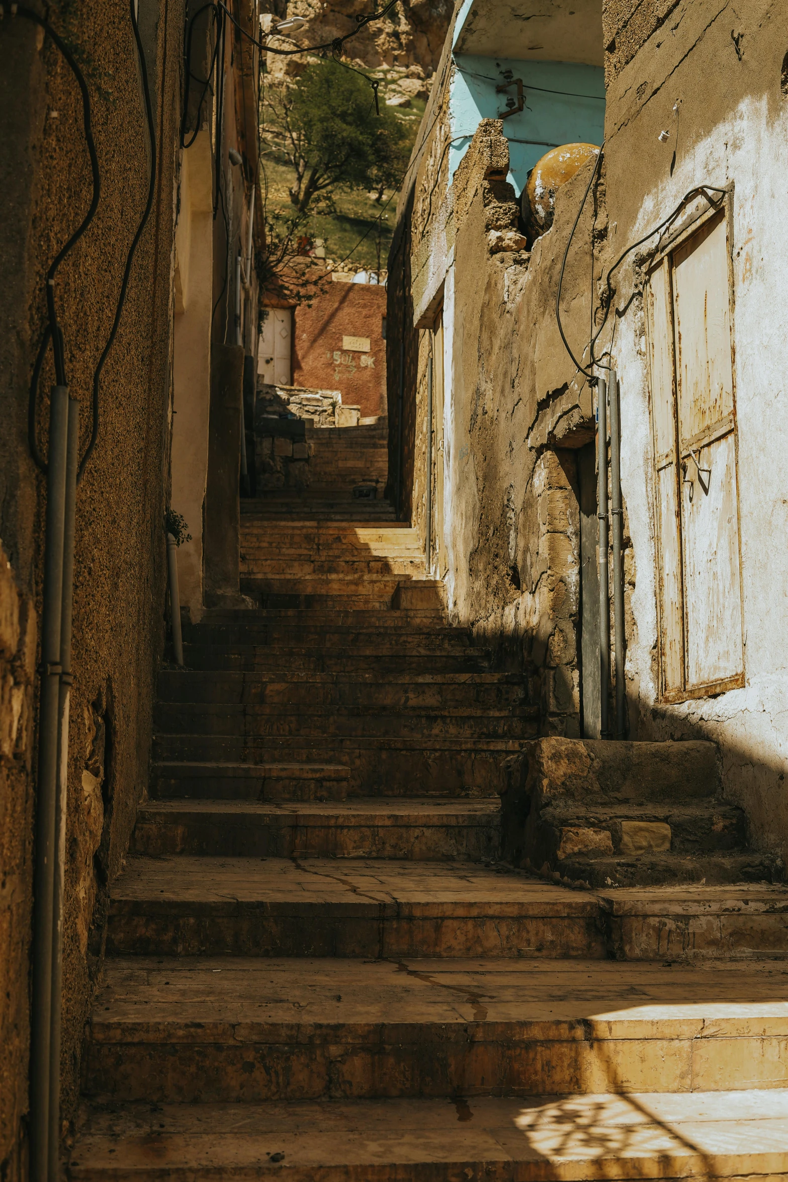 a set of stairs going up the side of a building, inspired by Carl Spitzweg, pexels contest winner, renaissance, jerusalem, shady alleys, distant photo, late afternoon