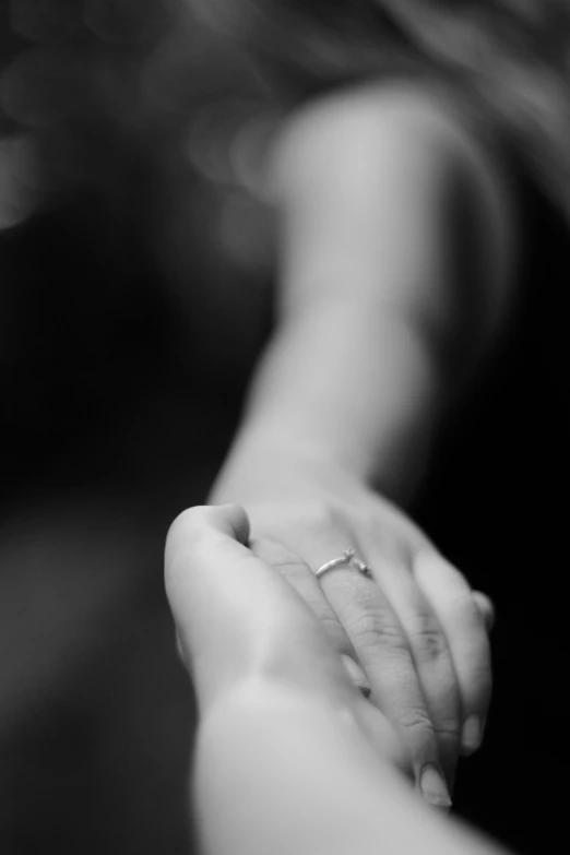 a close up of a person holding a person's hand, a black and white photo, love in motion, vannessa ives, from the distance, centred