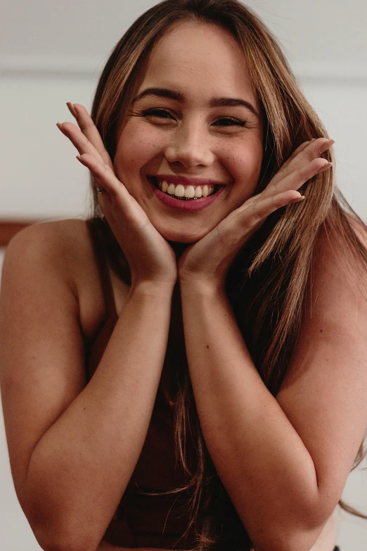 a woman posing for a picture with her hands on her face, trending on pexels, happening, crazy seductive smile, nubile body, bottom body close up, happily smiling at the camera