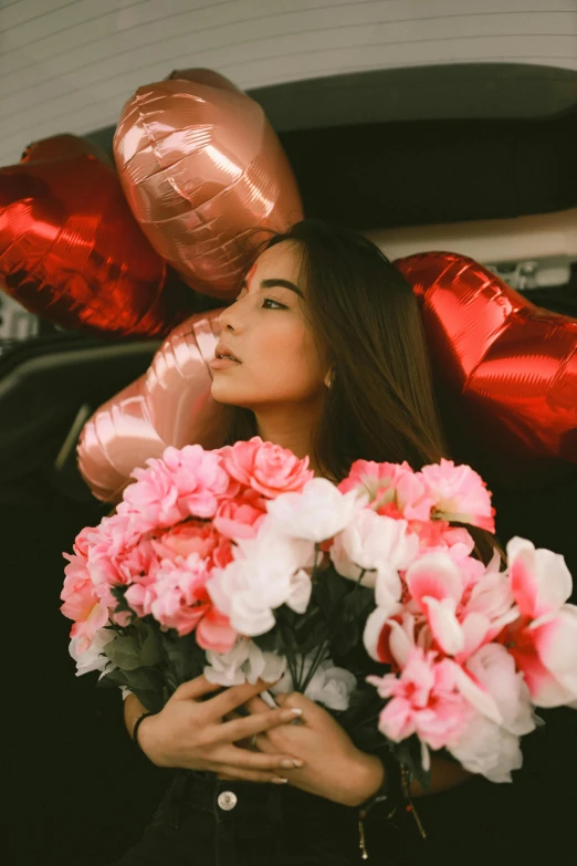 a woman holding a bunch of pink and white flowers, pexels contest winner, romanticism, balloons, :: madison beer, vietnamese woman, sitting in her car