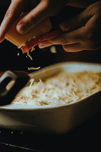 a person putting cheese on top of a casserole dish, pexels contest winner, process art, rice, dark warm light, commercial banner, cutlery