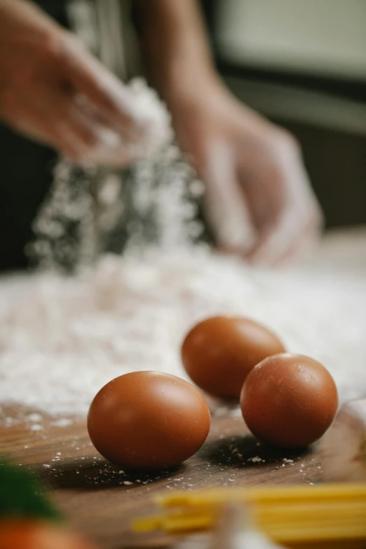 a person kneads eggs on a cutting board, a still life, trending on pexels, flour dust spray, paul barson, made of glazed, australian