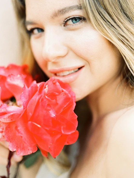 a woman holding a red rose in front of her face, by Julia Pishtar, diffused natural skin glow, miranda cosgrove, profile image, bougainvillea