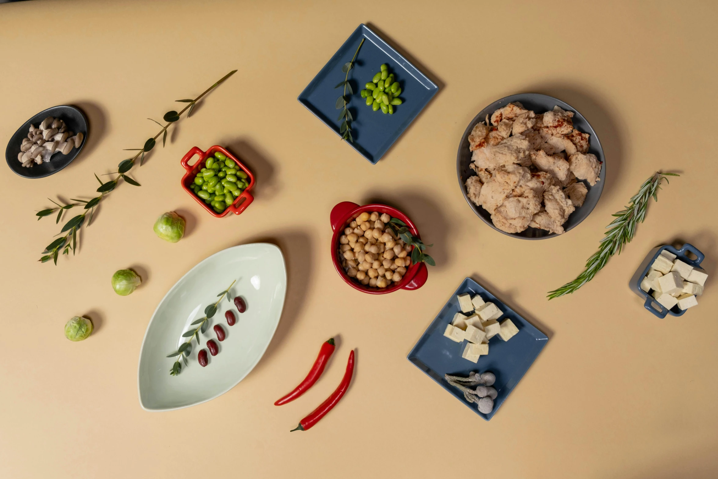 a table topped with bowls filled with different types of food, a still life, inspired by Ceferí Olivé, unsplash, olive green and venetian red, miniature product photo, plated arm, on grey background