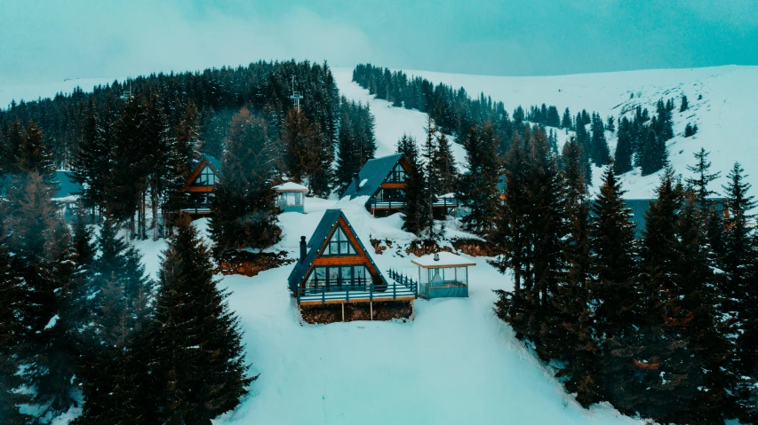 a group of cabins sitting on top of a snow covered slope, by Emma Andijewska, pexels contest winner, art nouveau, avatar image, drone footage, 90's photo, located in hajibektash complex