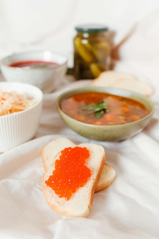 a couple of bowls of food sitting on top of a bed, brown bread with sliced salo, marmalade, sofya emelenko, good soup