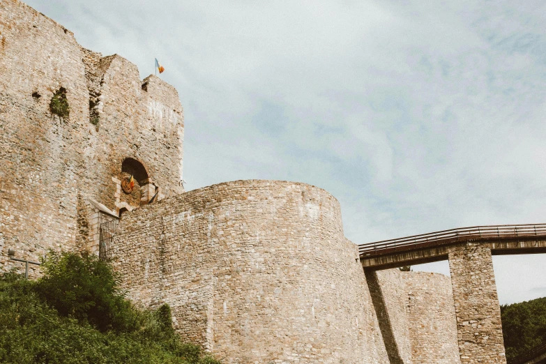 a large stone castle sitting on top of a lush green hillside, an album cover, pexels contest winner, renaissance, aqueduct and arches, exterior photo, beige, dover castle