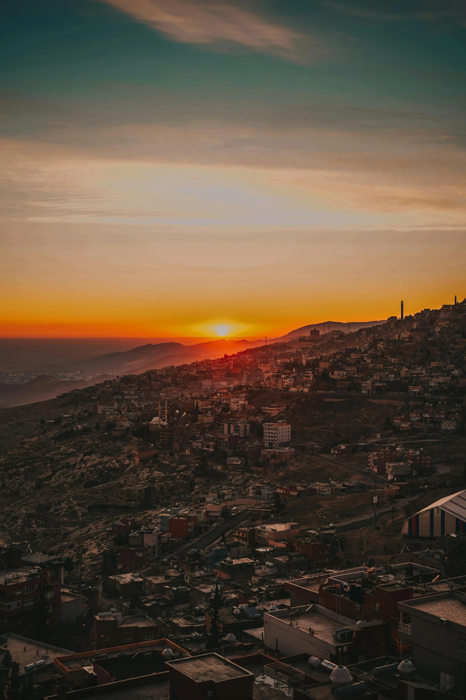 a view of a city from the top of a hill, an album cover, pexels contest winner, damascus, real sunset, hillside, maroon